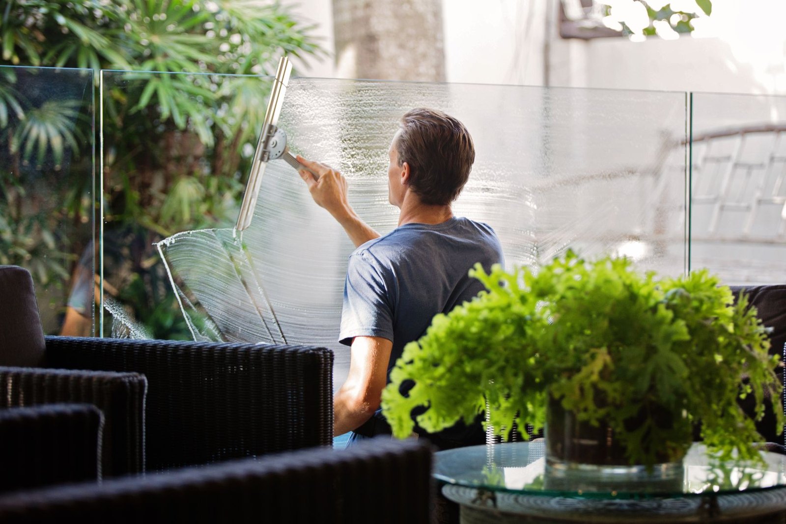 Professional cleaning commercial windows with a squeegee