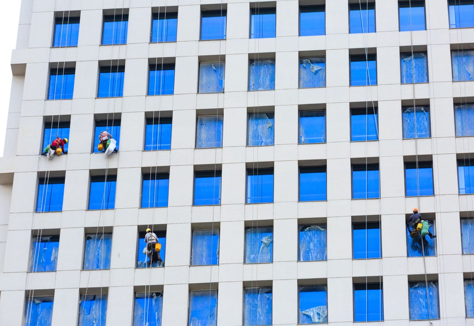 Professional window cleaners working on the exterior of a commercial building